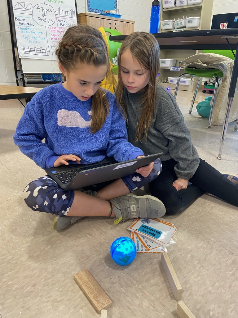 2 girls sharing a chromebook with a sphero robot